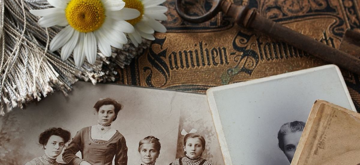 Vintage family photographs with daisies and an antique key evoke memories and nostalgia.