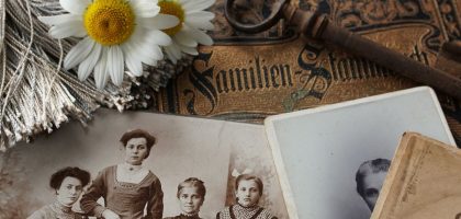 Vintage family photographs with daisies and an antique key evoke memories and nostalgia.