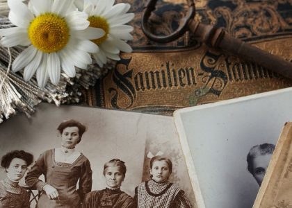 Vintage family photographs with daisies and an antique key evoke memories and nostalgia.